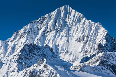 Scenic view of snowcapped mountains against clear blue sky