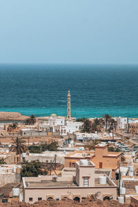 High angle view of townscape by sea against clear sky