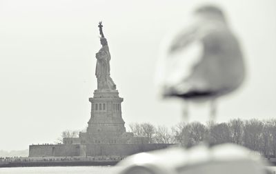 Statue in city against clear sky