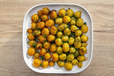 Potatoes boiled and then baked whole in the oven, lying on a plate.