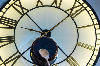 Low angle view of clock on ceiling of building