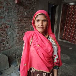 Portrait of woman standing against wall