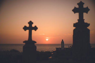 Christian cemetery and sunset over the sea tombstone built against the sea on the beach at nagasaki