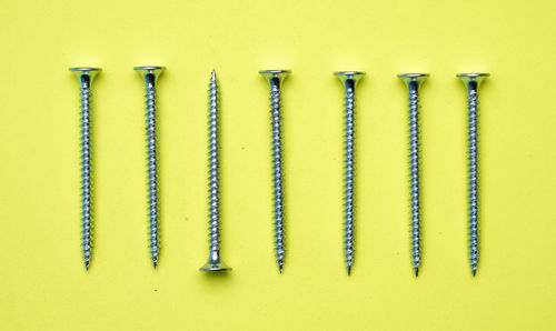 Close-up of metallic objects on table against wall