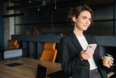 Portrait of young businesswoman standing in office