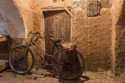 Bicycle parked against brick wall