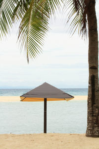Lifeguard hut on beach against sky