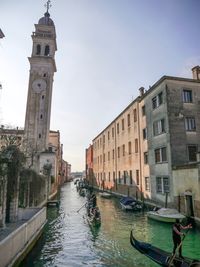 Canal passing through buildings in city