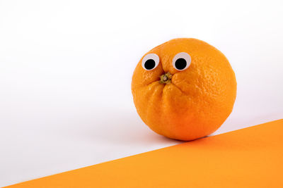 Close-up of orange fruit against white background