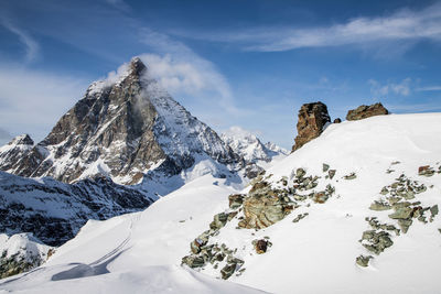 Low angle view of snowcapped mountains against sky