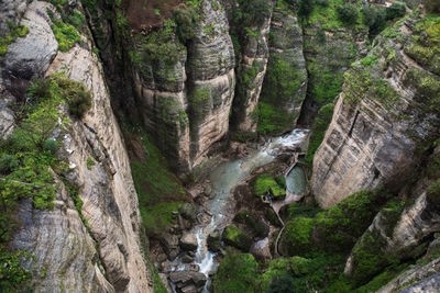 High angle view of river flowing amidst rock formations in forest