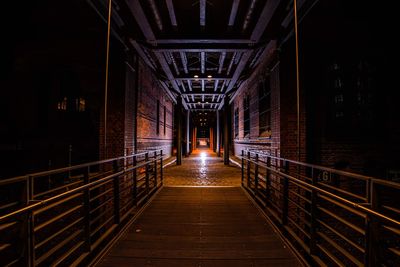 Diminishing perspective of empty footbridge at night