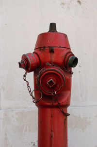 Close-up of red fire hydrant against wall