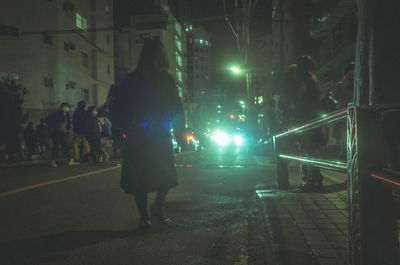 Low section of man walking on road at night