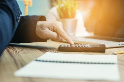 Midsection of person using laptop on table