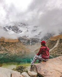 Rear view of woman standing on mountain against sky