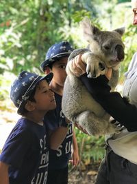 Woman with sons holding koala