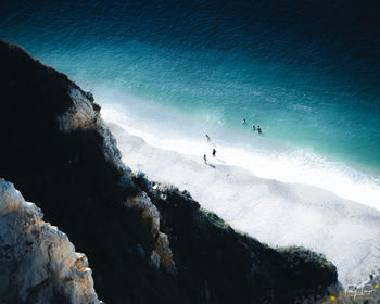 High angle view of people on rocks by sea