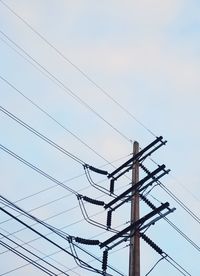 Low angle view of electricity pylon against clear sky