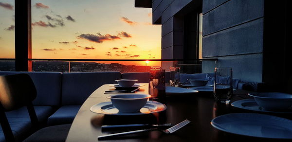 View of restaurant glass window on table at sunset