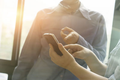 Midsection of man using mobile phone