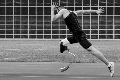 Full length of woman exercising on field