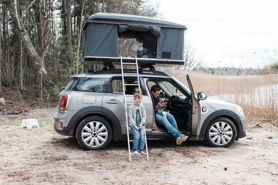 Family camping by the beach in roof top tent