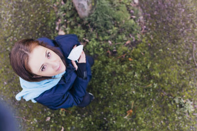 Portrait of a smiling young woman lying on land