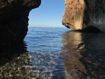 Rock formation on sea against sky