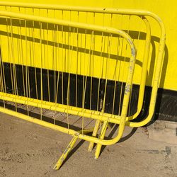 Yellow metallic structure on road against wall