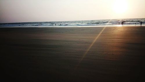 Scenic view of beach against clear sky during sunset