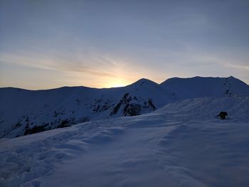 Scenic view of snow covered mountains against sky during sunset