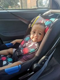 Portrait of cute girl sitting in car