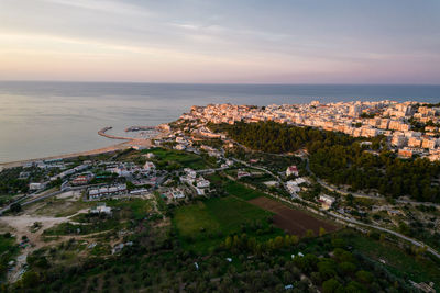 High angle view of townscape by sea against sky