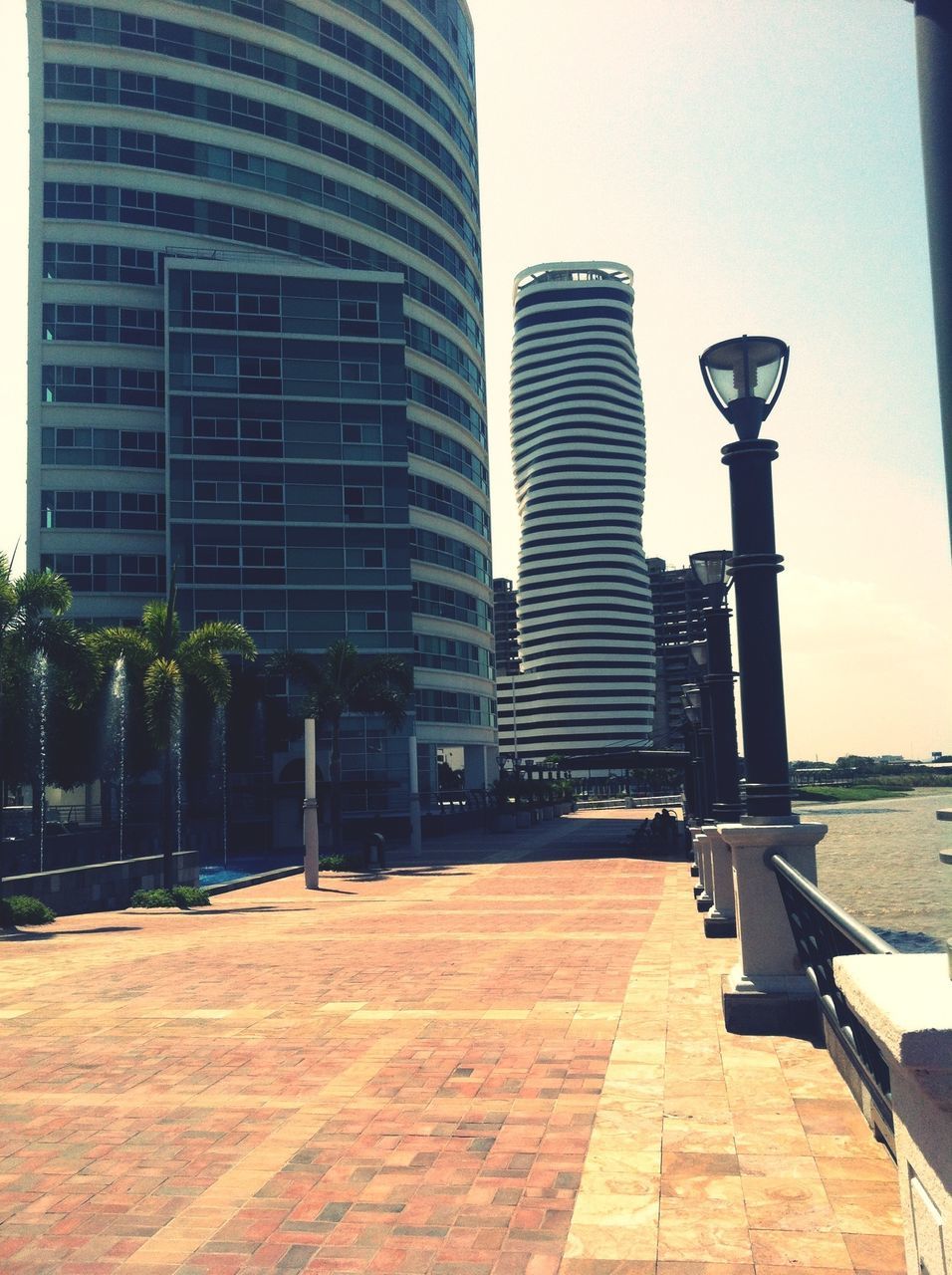 architecture, building exterior, built structure, city, modern, office building, building, empty, street, the way forward, day, city life, skyscraper, sky, street light, sidewalk, tall - high, outdoors, sunlight, tower