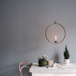 Lit candle above potted plants on table at home