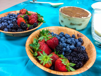 High angle view of berry fruits in bowls on table