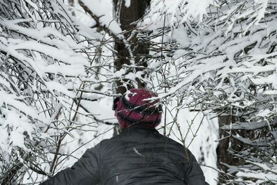 Woman covering face on snow covered landscape