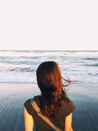 Rear view of woman looking at sea against sky