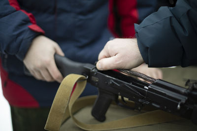 Midsection of man holding gun