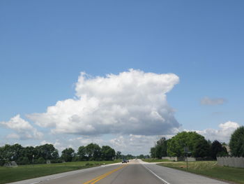 Empty road with trees in background