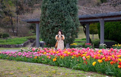 Woman standing by flowering plants