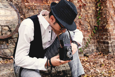 Male photographer using vintage medium format photo camera.