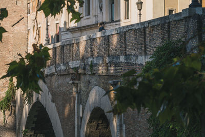 Arch bridge over canal amidst buildings in city