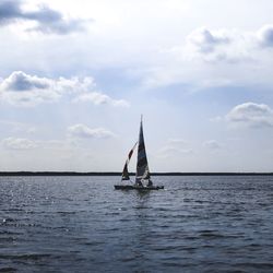 Sailboat sailing on sea against sky