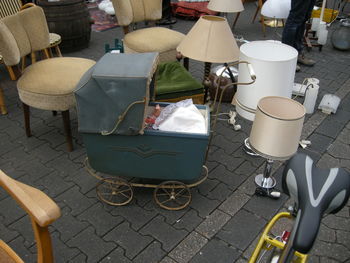 High angle view of baby in carriage by chairs on street