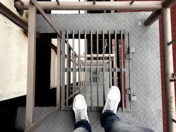 Low section of man standing on metal grate