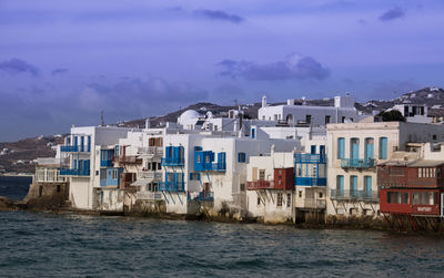 Houses by sea against sky