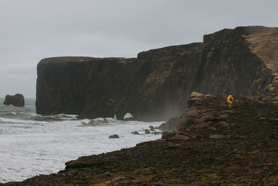 Man on cliff by sea