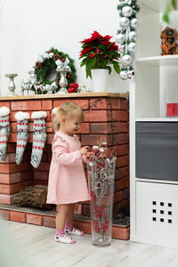 Rear view of woman standing by christmas tree